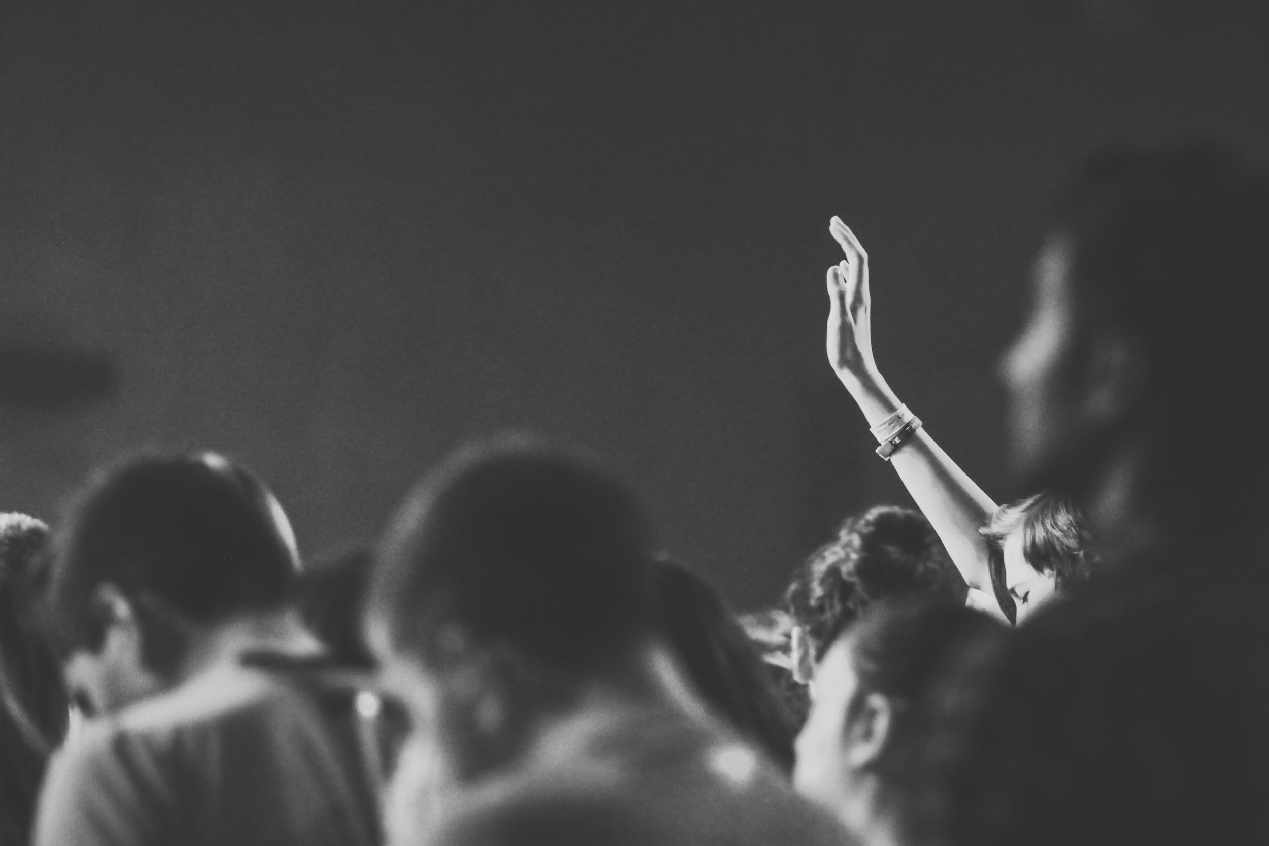A person raising their hand in an audience